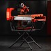 Orange tile saw on a portable stand.